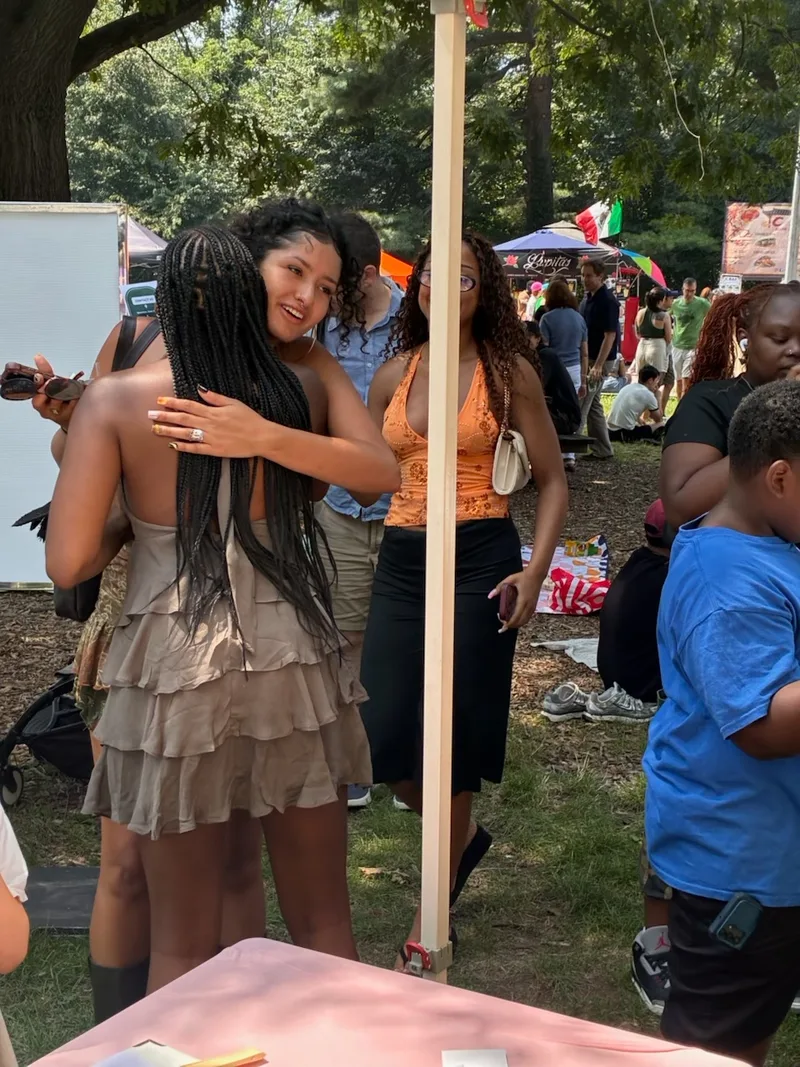 Two women hugging at the Families Beyond Bars booth during the July 19 event in Prospect Park