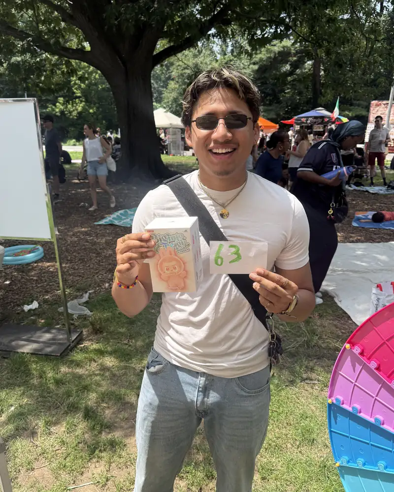 A visitor smiling and holding up his prize at the Families Beyond Bars booth