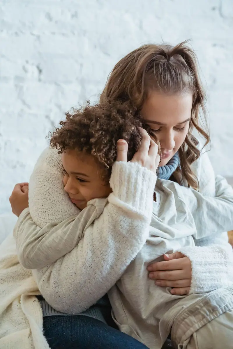 A mother holding her young son close in a warm embrace